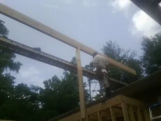 Carpenter setting a ridge beam over a new addition frame — Ice Dam Removal by Roofing Brothers in Hazlet