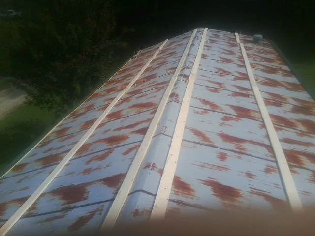 Rusted metal roof panels with new wood purlins before replacement — Storm Damage Roof Repair in Hazlet by Roofing Brothers