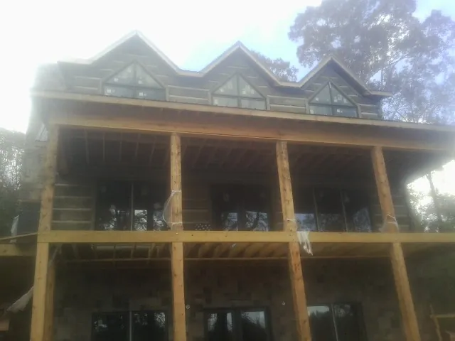 Dormers and porch framing on a large log home under construction — Roof Coating work by our crew in Hazlet