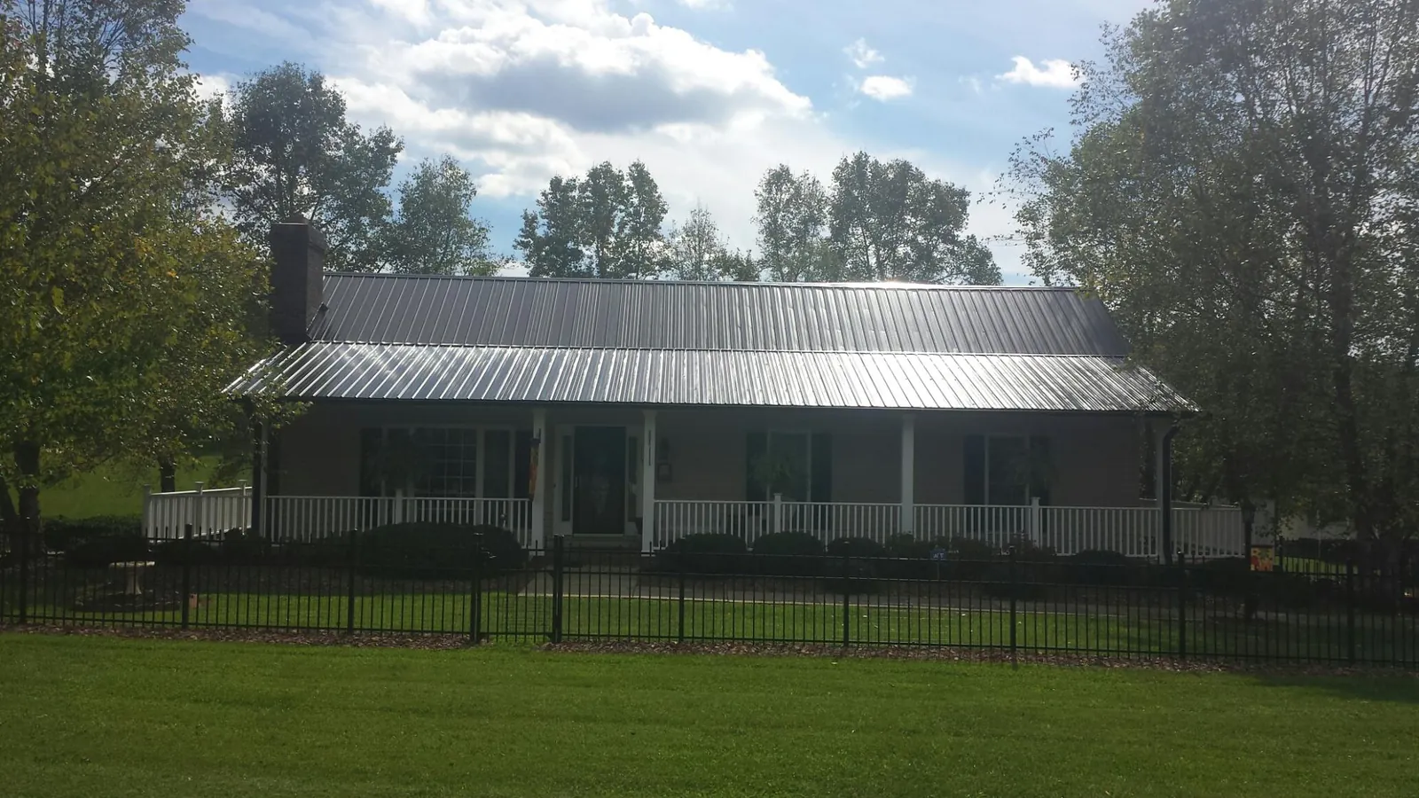 Gray metal roof on a brick ranch with a full width front porch — Gutter Guard Installation work by our crew in Hazlet
