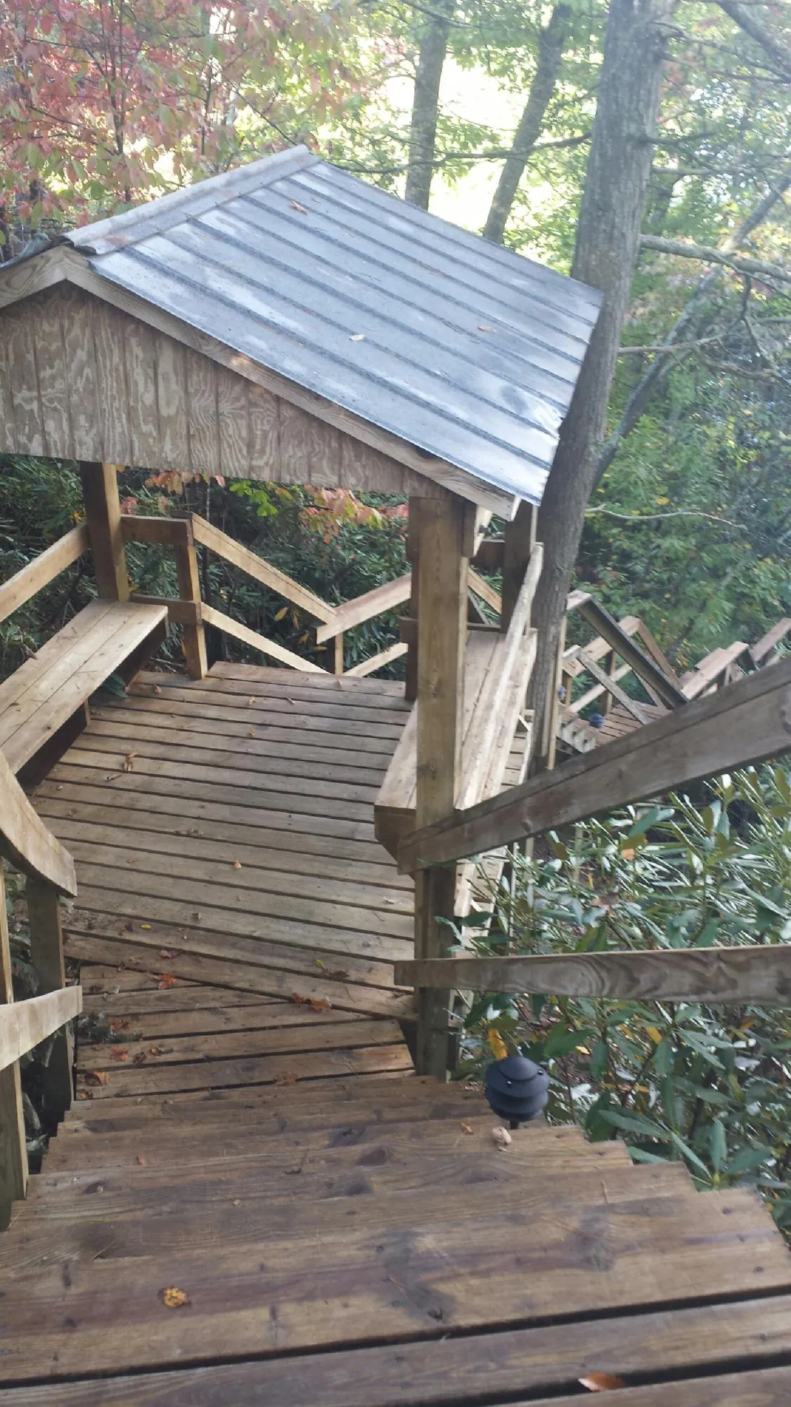 Metal roofed shelter over wooden steps on a wooded walkway — Skylight Repair & Installation work by our crew in Hazlet