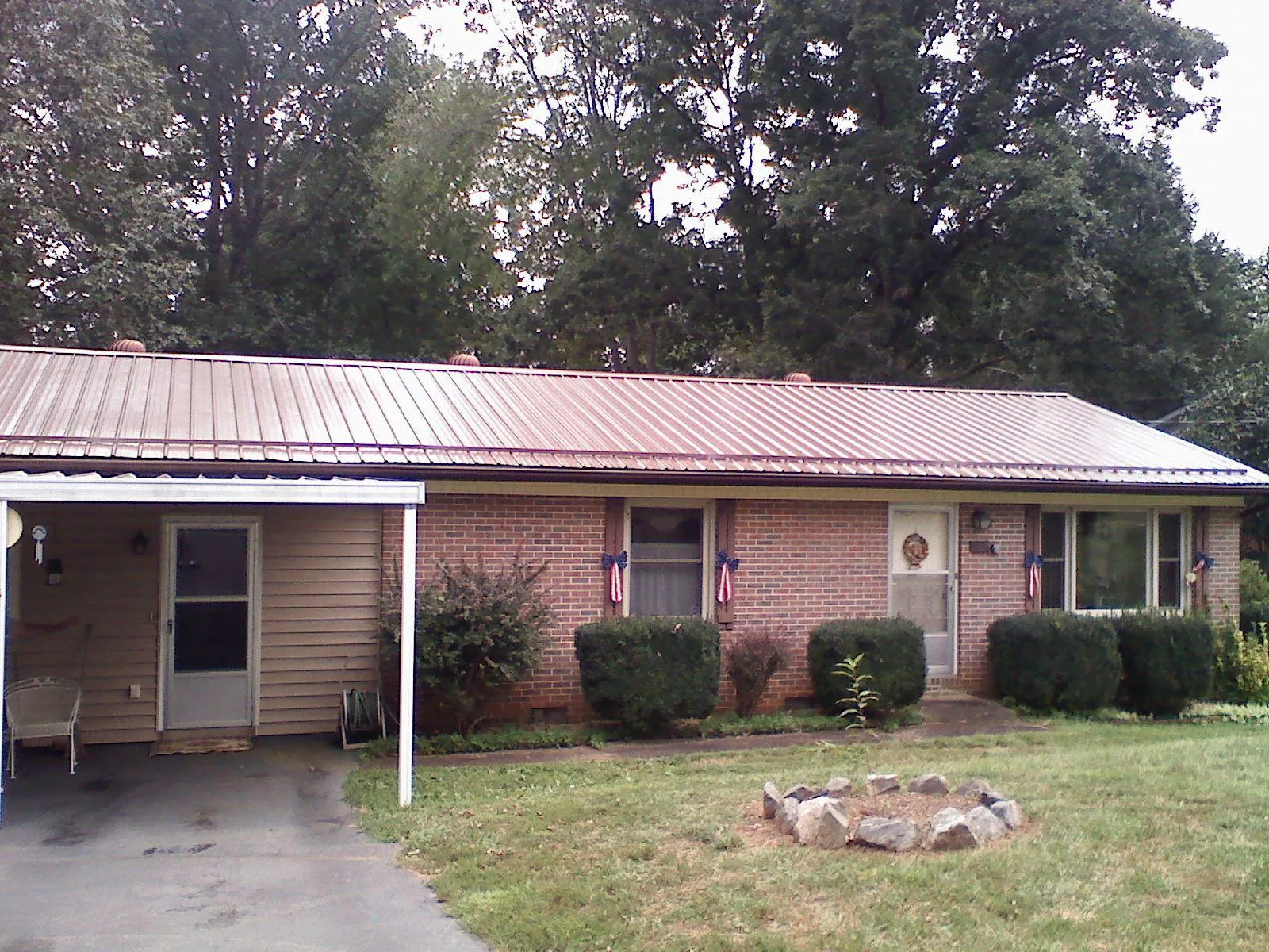 Bronze metal roof and carport on a brick ranch home — Roof Repair work by our crew in Hazlet